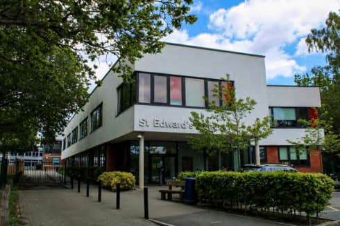 Weißes Schulgebäude mit Schriftzug „St Edward's“ hinter Bäumen in Südwestengland
