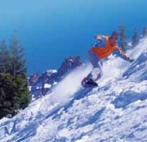 Snowboarder in oranger Jacke im Tiefschnee – Wintersport im Auslandsjahr in Alberta