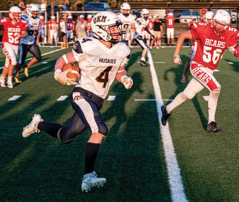 High-School-Football in Kanada: Huskies-Spieler läuft mit dem Ball, verfolgt von den Bears