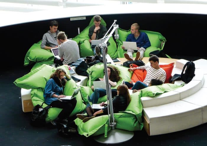 Schüler:innen mit Laptops auf grünen Sitzsäcken in einer Lernlounge in Skandinavien