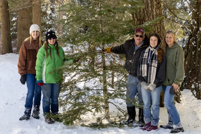 Fünf Personen neben einer Tanne im verschneiten Wald – Winter im Auslandsjahr in den USA