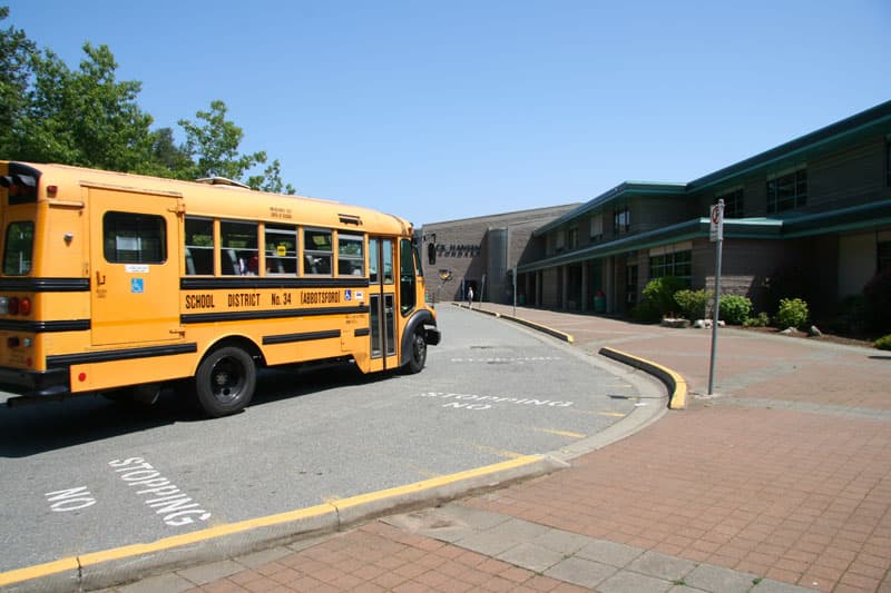 Gelber Schulbus vor einer High School in Kanada