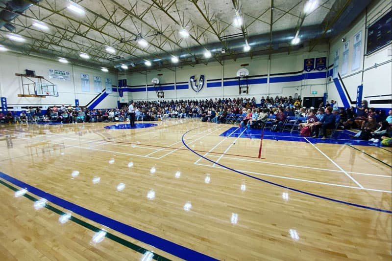 Schulversammlung in der voll besetzten Sporthalle einer High School in Kanada