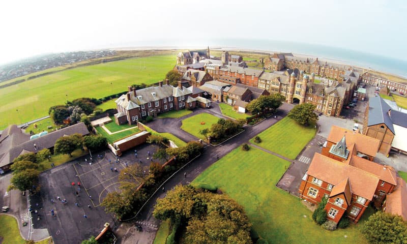 Luftaufnahme eines Schulgeländes mit Backsteingebäuden am Meer – Schüleraustausch in England