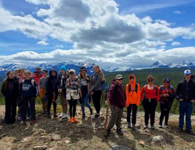 Austauschschüler:innen auf Wandertour vor schneebedeckten Bergen in Alberta