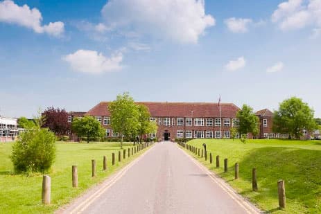 Gerader Zufahrtsweg zu einem roten Backsteinschulgebäude in Südwestengland