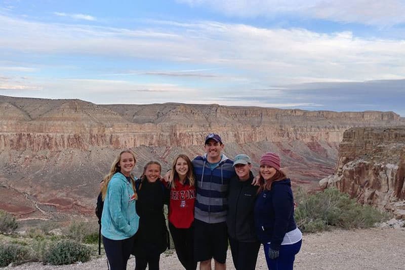 Austauschschüler:innen am Rand einer Canyonlandschaft mit roten Felswänden in den USA