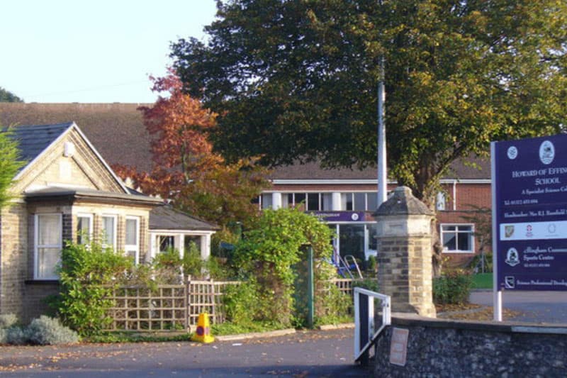 Schuleingang mit Steinpfeiler, Hinweisschild und älterem Gebäude in Südostengland