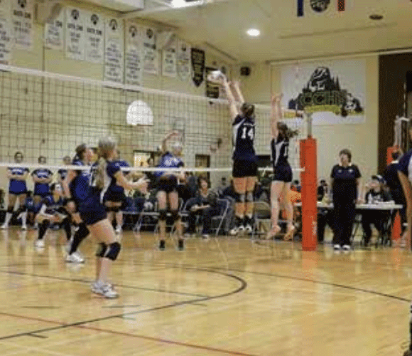 Volleyballspiel von Schülerinnen in der Sporthalle einer High School in Alberta