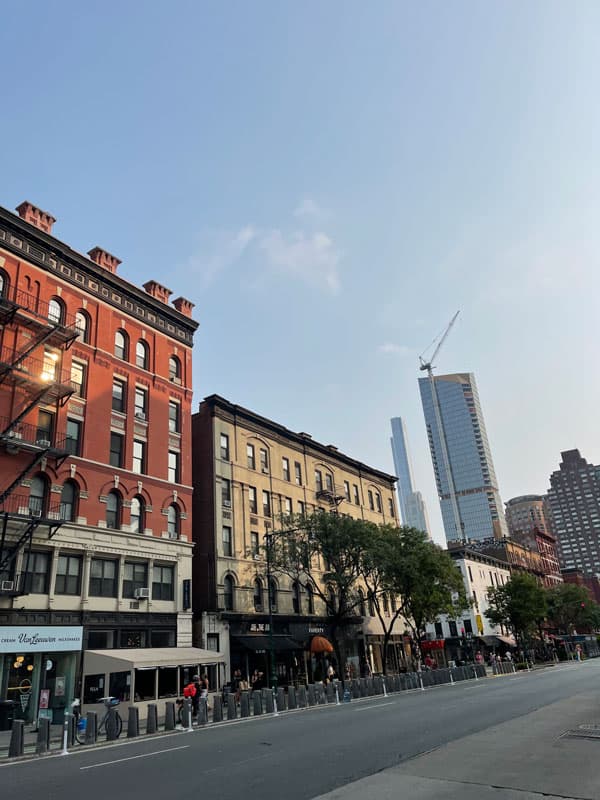 Straße mit alten Backsteinhäusern und Wolkenkratzern in New York