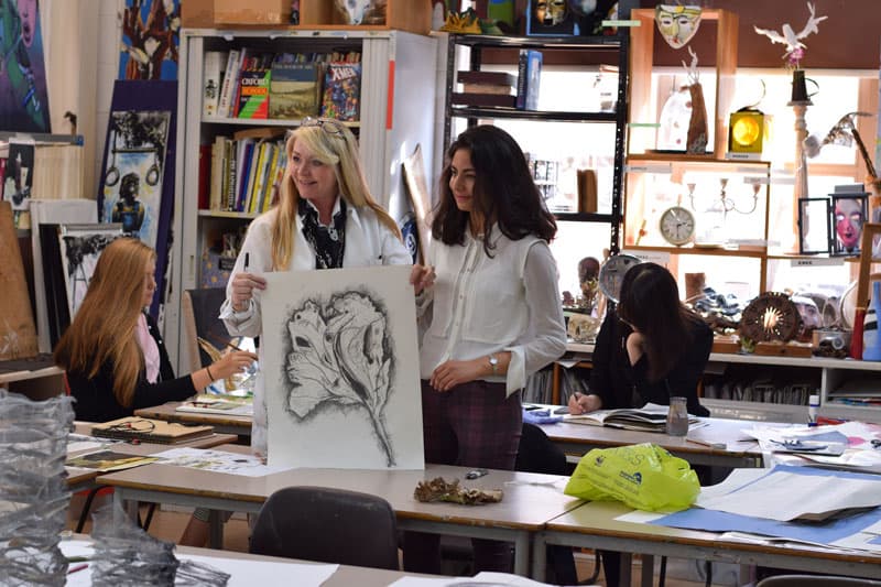 Kunstunterricht in England: Schülerinnen besprechen im Atelier eine Kohlezeichnung